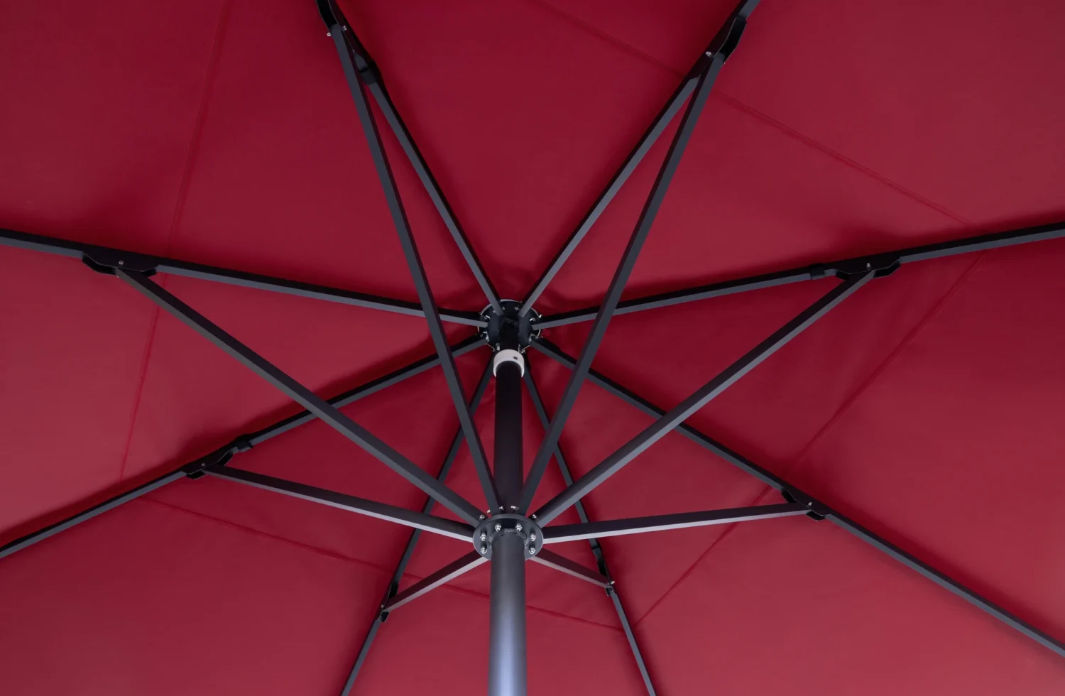 Innenansicht eines roten Sonnenschirms mit stabiler Metallstruktur